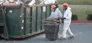 Water damage Brazoria technicians removing debris to street dumpster