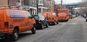 water damage restoration vans and trucks lined up at urban job location